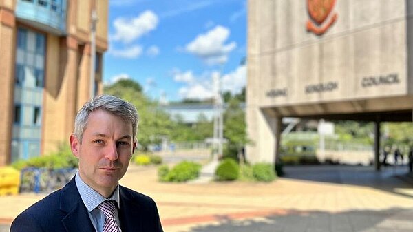 Will Forster stands outside the Woking Borough Council offices